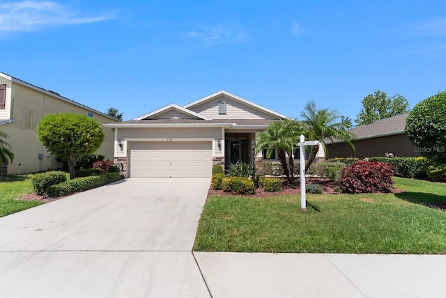 6124 35th Ct E, Bradenton, FL 34203 - view of front of house with a front yard, driveway, stone siding, and a garage