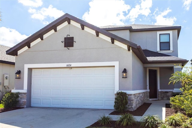 view of front of house with stone siding, driveway, and stucco siding