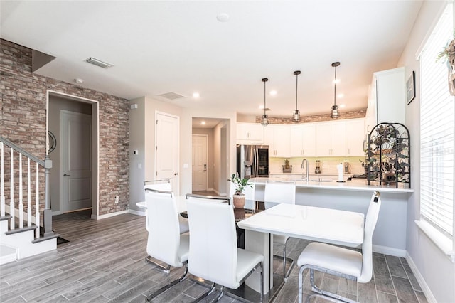dining room with stairway, visible vents, baseboards, and wood finished floors