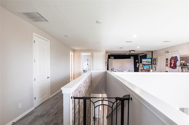 hall with carpet flooring, visible vents, and baseboards