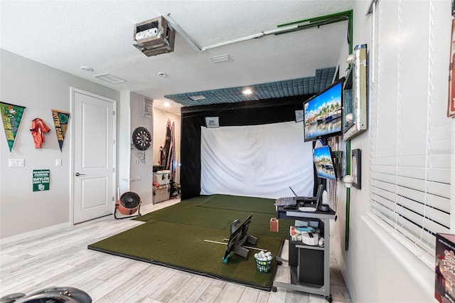 playroom with baseboards, wood finished floors, and a textured ceiling