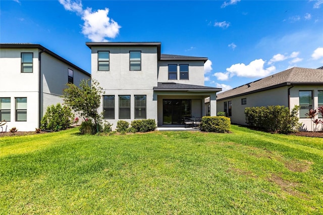 rear view of property featuring a patio area, stucco siding, and a lawn