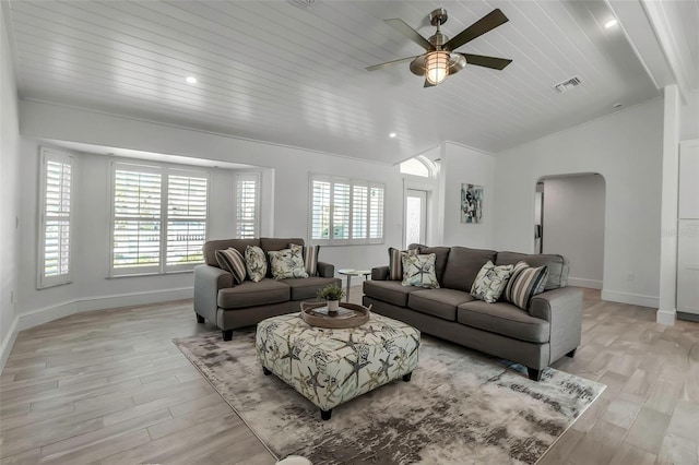 living room with arched walkways, vaulted ceiling, plenty of natural light, and a ceiling fan