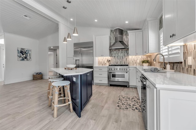 kitchen with wall chimney exhaust hood, vaulted ceiling, premium appliances, decorative backsplash, and a breakfast bar area