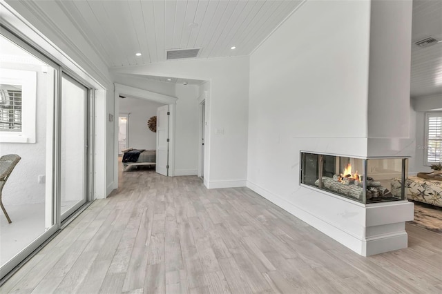interior space featuring visible vents, recessed lighting, light wood-type flooring, and vaulted ceiling