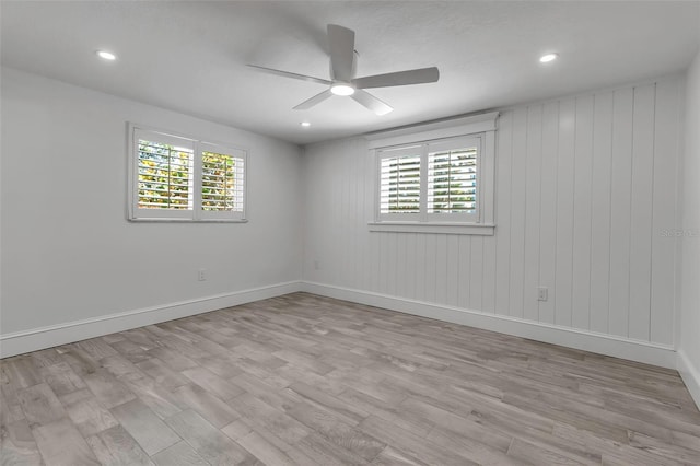 unfurnished room featuring baseboards, a ceiling fan, light wood-style floors, and a healthy amount of sunlight