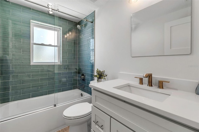 bathroom featuring toilet, shower / bath combination with glass door, and vanity