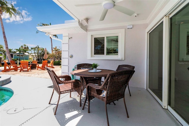 view of patio with outdoor dining area and a ceiling fan