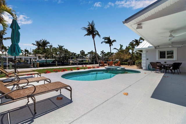 view of swimming pool featuring a patio area, a pool with connected hot tub, and ceiling fan