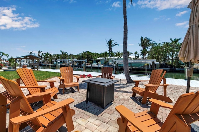 view of patio featuring a boat dock, a fire pit, boat lift, and a water view