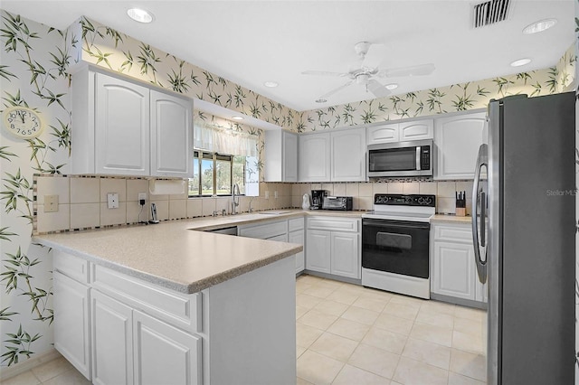 4360 Presidential Avenue Cir E, Bradenton, FL 34203 - kitchen with a peninsula, visible vents, appliances with stainless steel finishes, wallpapered walls, and decorative backsplash