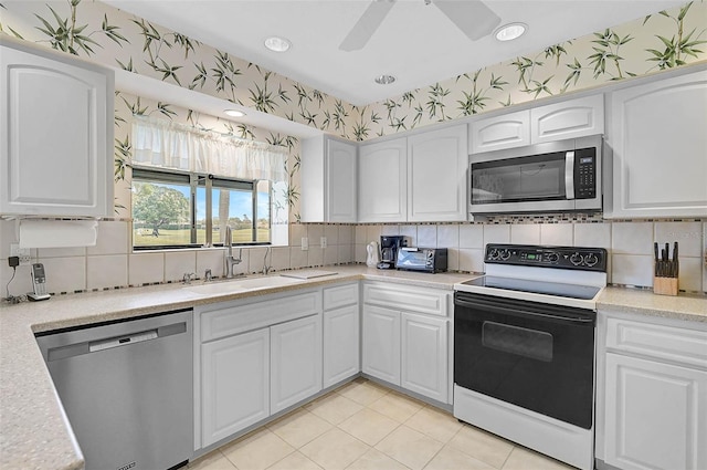 4360 Presidential Avenue Cir E, Bradenton, FL 34203 - kitchen with wallpapered walls, a sink, backsplash, and stainless steel appliances