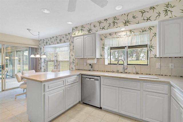 4360 Presidential Avenue Cir E, Bradenton, FL 34203 - kitchen featuring stainless steel dishwasher, white cabinets, light countertops, and wallpapered walls