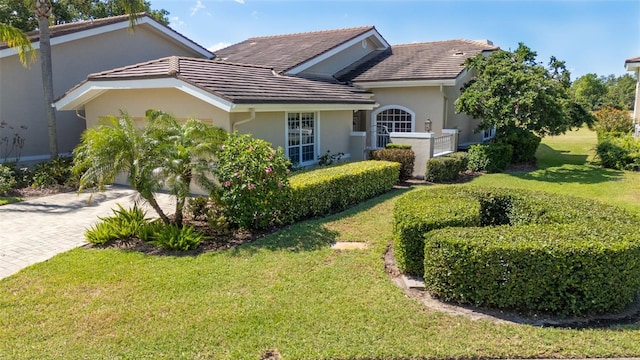 4044 Penshurst Park, Sarasota, FL 34235 - view of front of property with a tiled roof, stucco siding, decorative driveway, a front yard, and a garage