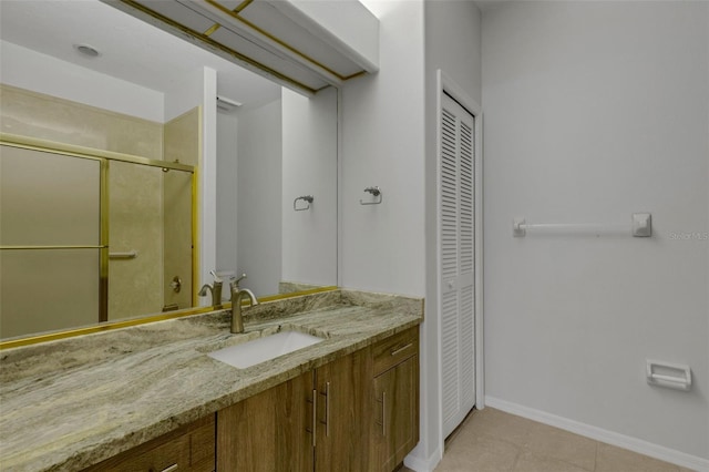 4044 Penshurst Park, Sarasota, FL 34235 - bathroom featuring a closet, baseboards, a shower stall, vanity, and tile patterned floors
