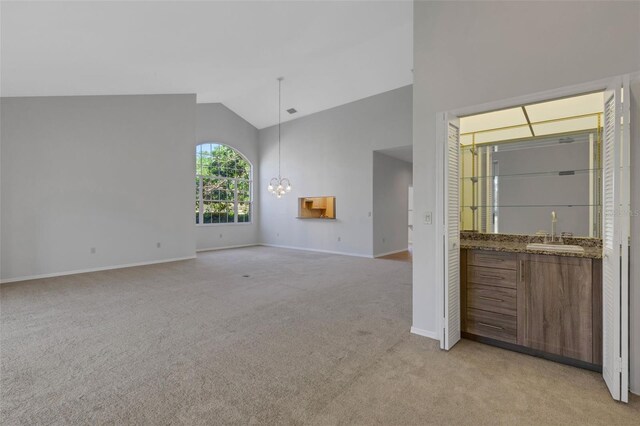 4044 Penshurst Park, Sarasota, FL 34235 - interior space with baseboards, light carpet, a chandelier, high vaulted ceiling, and a sink