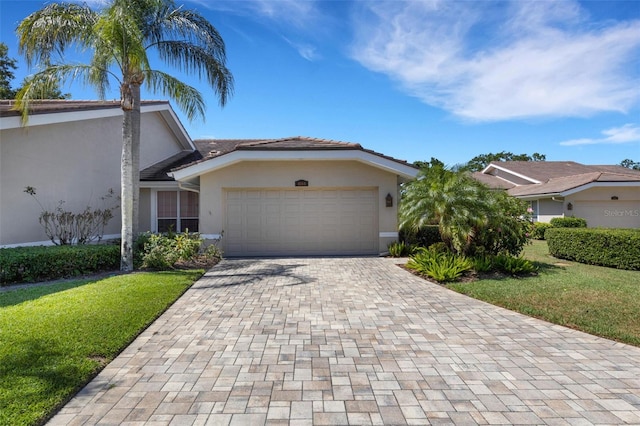 4044 Penshurst Park, Sarasota, FL 34235 - view of front of home featuring a garage, stucco siding, a front lawn, and decorative driveway