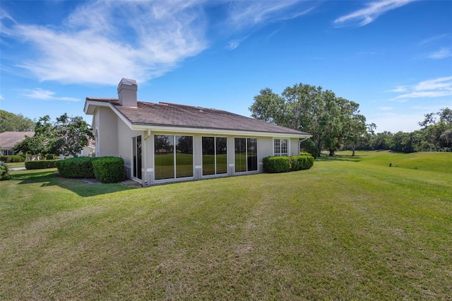 4044 Penshurst Park, Sarasota, FL 34235 - back of house with a yard, stucco siding, and a chimney