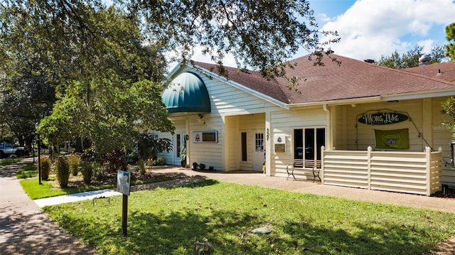 4044 Penshurst Park, Sarasota, FL 34235 - view of front of property with a patio, roof with shingles, and a front lawn