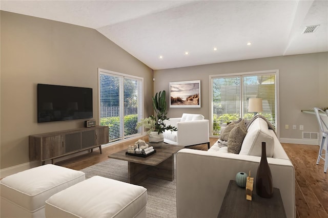 living area with plenty of natural light, vaulted ceiling, wood finished floors, and recessed lighting