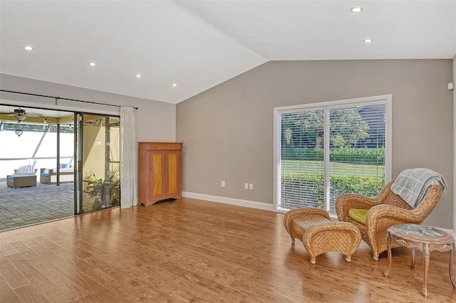 living area with recessed lighting, vaulted ceiling, light wood finished floors, and baseboards