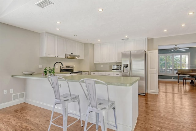 kitchen with stainless steel appliances, visible vents, and light wood-style floors