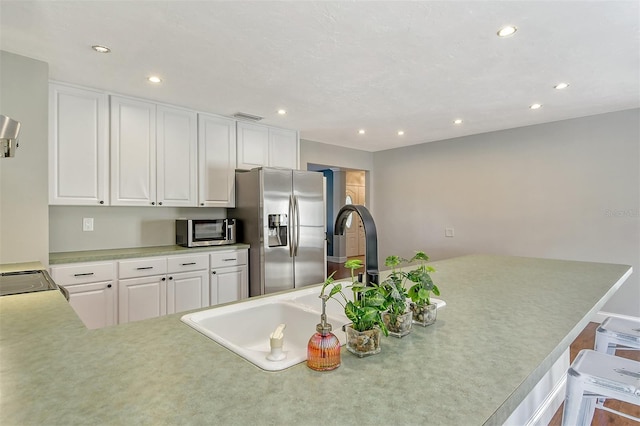 kitchen with stainless steel fridge with ice dispenser, light countertops, white cabinets, visible vents, and recessed lighting