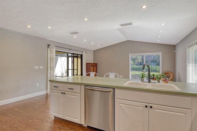 kitchen with light wood-style flooring, a sink, vaulted ceiling, white cabinetry, and dishwasher