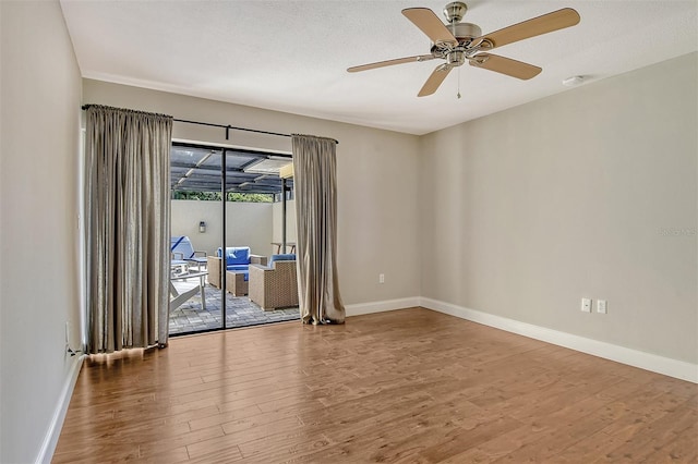 unfurnished room with baseboards, a ceiling fan, and wood finished floors
