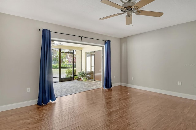 unfurnished room with wood finished floors, baseboards, and ceiling fan