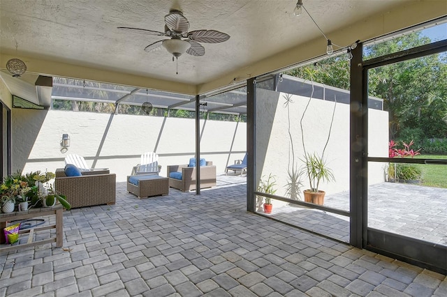 sunroom / solarium featuring a ceiling fan and an outdoor living space