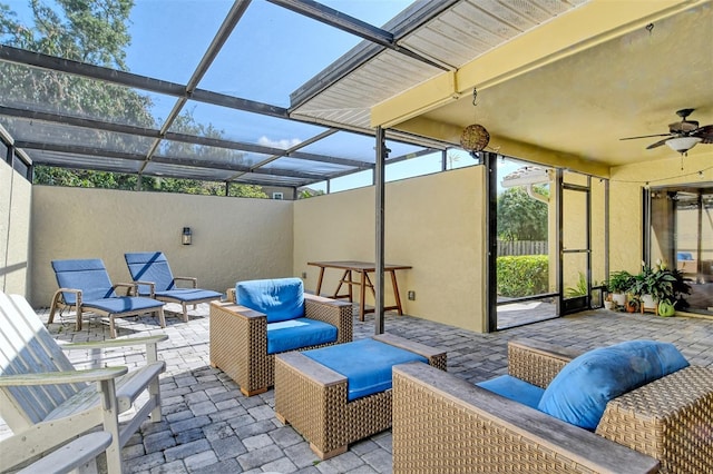 sunroom featuring a wealth of natural light, ceiling fan, and an outdoor hangout area