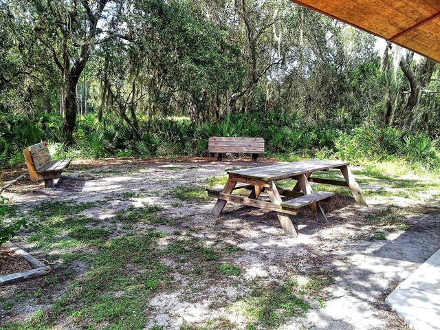 view of yard with outdoor dining area and a wooded view