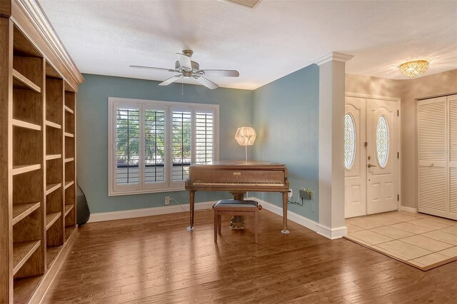foyer with wood-type flooring, baseboards, and ceiling fan