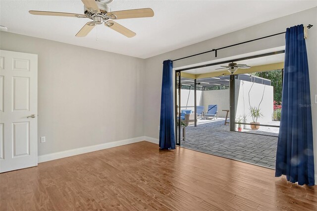 unfurnished room featuring ceiling fan, baseboards, and wood finished floors