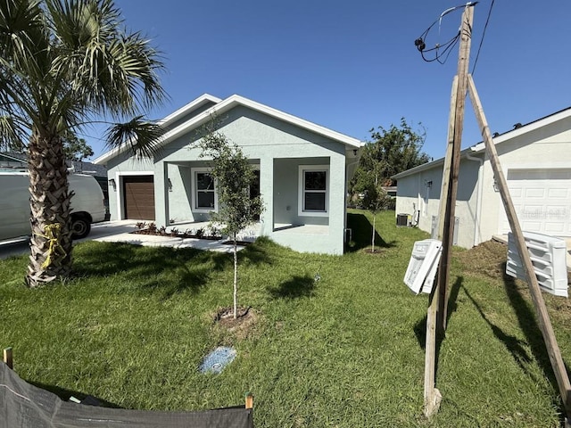 8810 N Mulberry St, Tampa, FL 33604 - view of front of house featuring cooling unit, a garage, stucco siding, and a front lawn