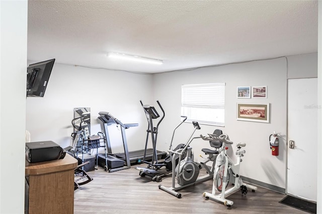 2300 Stickney Point Rd Unit 125, Sarasota, FL 34231 - workout room with wood finished floors and a textured ceiling