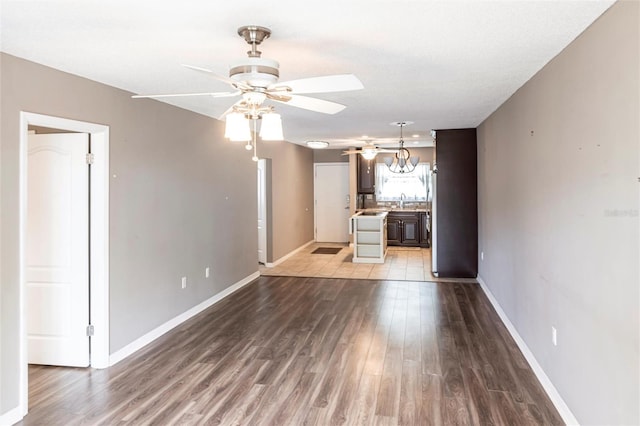 2300 Stickney Point Rd Unit 125, Sarasota, FL 34231 - unfurnished living room featuring ceiling fan, wood finished floors, and baseboards