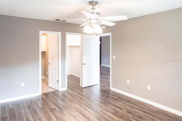 2300 Stickney Point Rd Unit 125, Sarasota, FL 34231 - unfurnished bedroom with a spacious closet, baseboards, and wood finished floors