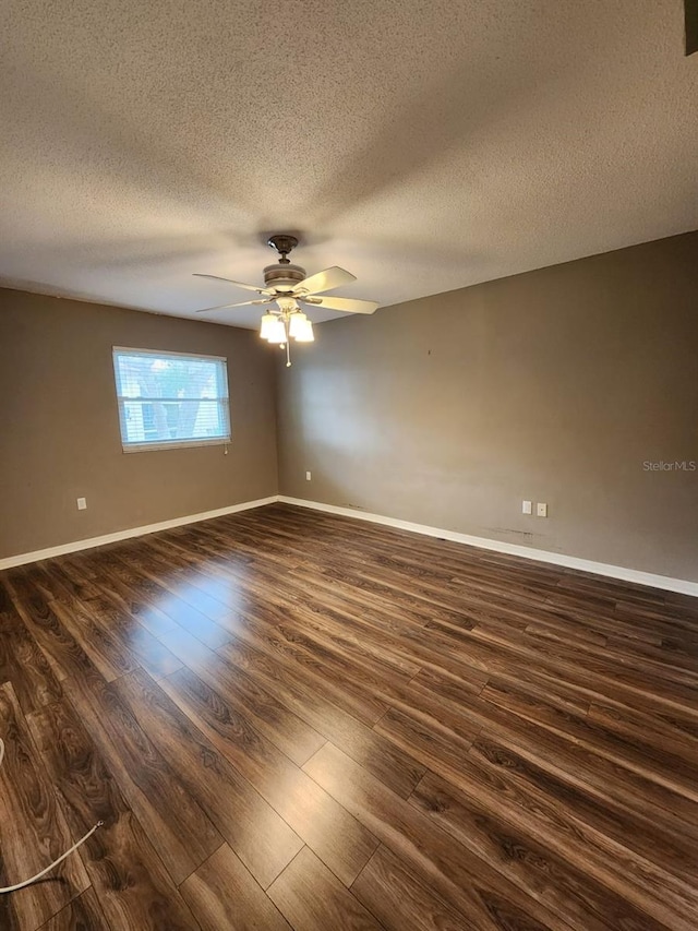 2300 Stickney Point Rd Unit 125, Sarasota, FL 34231 - empty room with dark wood-style flooring, ceiling fan, a textured ceiling, and baseboards