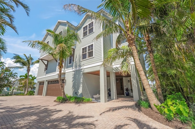 526 56th St, Holmes Beach, FL 34217 - coastal inspired home featuring a garage and decorative driveway