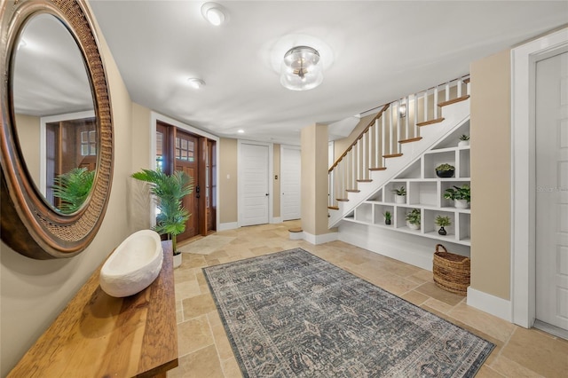 526 56th St, Holmes Beach, FL 34217 - entrance foyer with stairs, stone tile floors, and baseboards