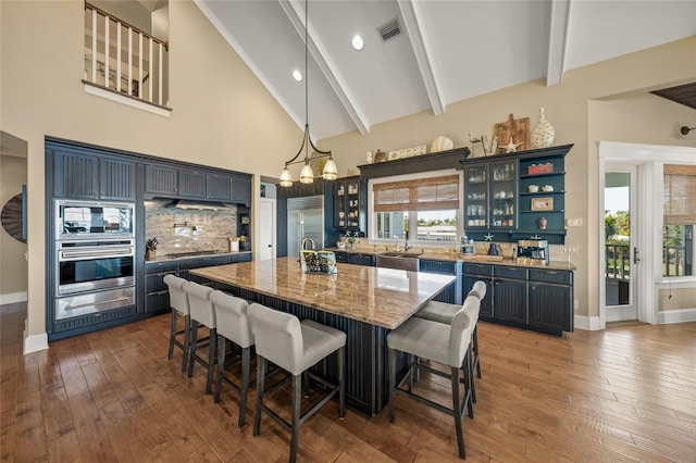 526 56th St, Holmes Beach, FL 34217 - interior space featuring visible vents, a healthy amount of sunlight, beam ceiling, high vaulted ceiling, and hardwood / wood-style floors