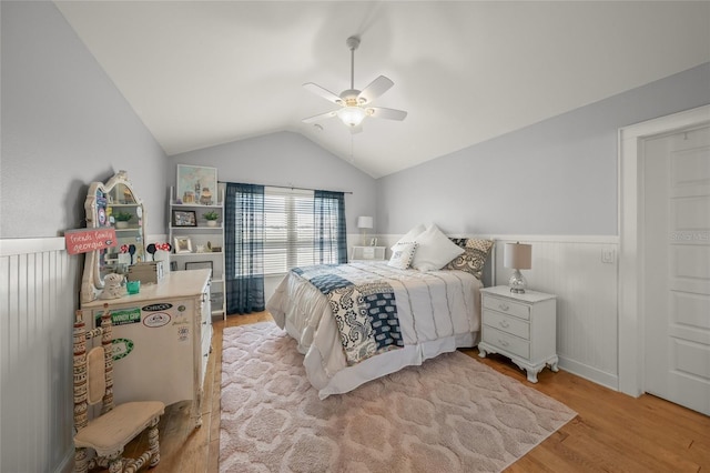 526 56th St, Holmes Beach, FL 34217 - bedroom with light wood-style flooring, a ceiling fan, lofted ceiling, and a wainscoted wall