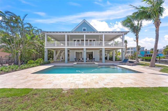 526 56th St, Holmes Beach, FL 34217 - rear view of house featuring a patio, stairway, an in ground hot tub, and an outdoor pool