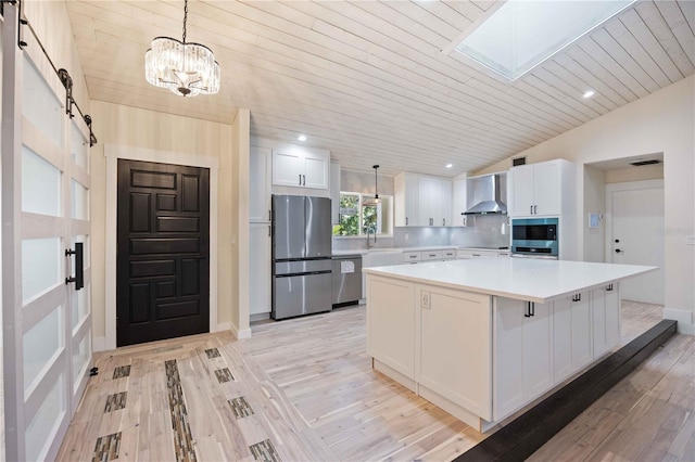 4916 Hidden Oaks Trl, Sarasota, FL 34232 - kitchen featuring stainless steel appliances, wall chimney exhaust hood, a barn door, light countertops, and white cabinets