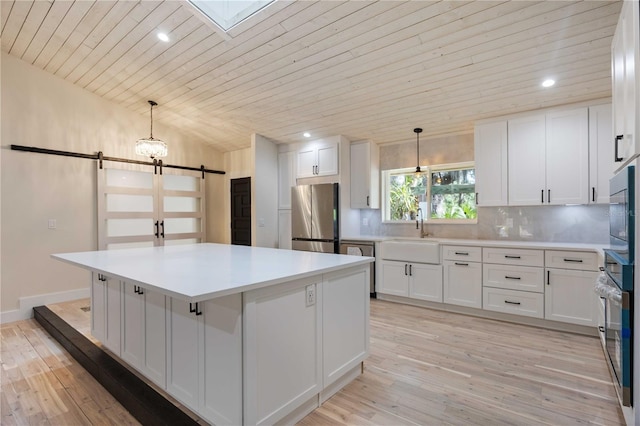 4916 Hidden Oaks Trl, Sarasota, FL 34232 - kitchen featuring stainless steel appliances, a barn door, wooden ceiling, white cabinetry, and backsplash