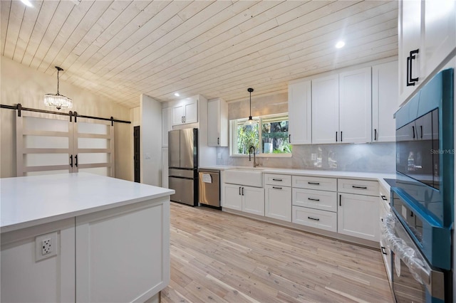 4916 Hidden Oaks Trl, Sarasota, FL 34232 - kitchen with a barn door, appliances with stainless steel finishes, wooden ceiling, a sink, and white cabinets