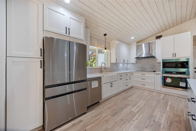 4916 Hidden Oaks Trl, Sarasota, FL 34232 - kitchen featuring appliances with stainless steel finishes, wall chimney range hood, a sink, light countertops, and light wood-type flooring