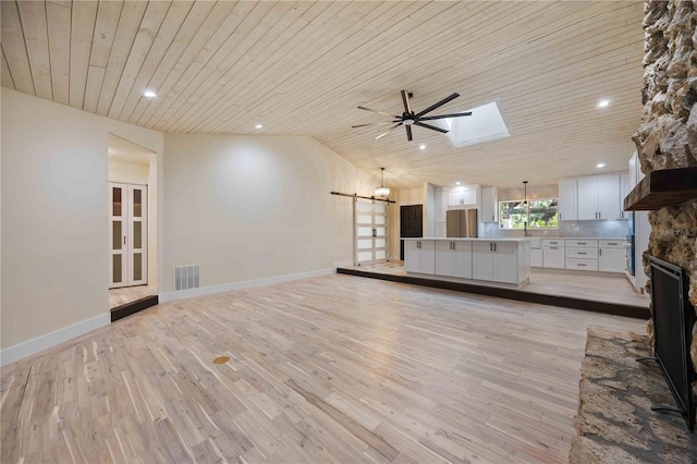4916 Hidden Oaks Trl, Sarasota, FL 34232 - unfurnished living room featuring wooden ceiling, ceiling fan, light wood finished floors, a skylight, and a fireplace
